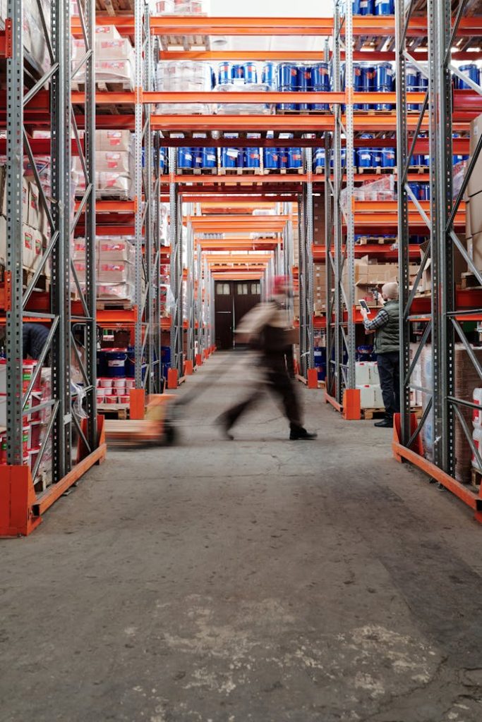 A Man Walking Inside the Warehouse